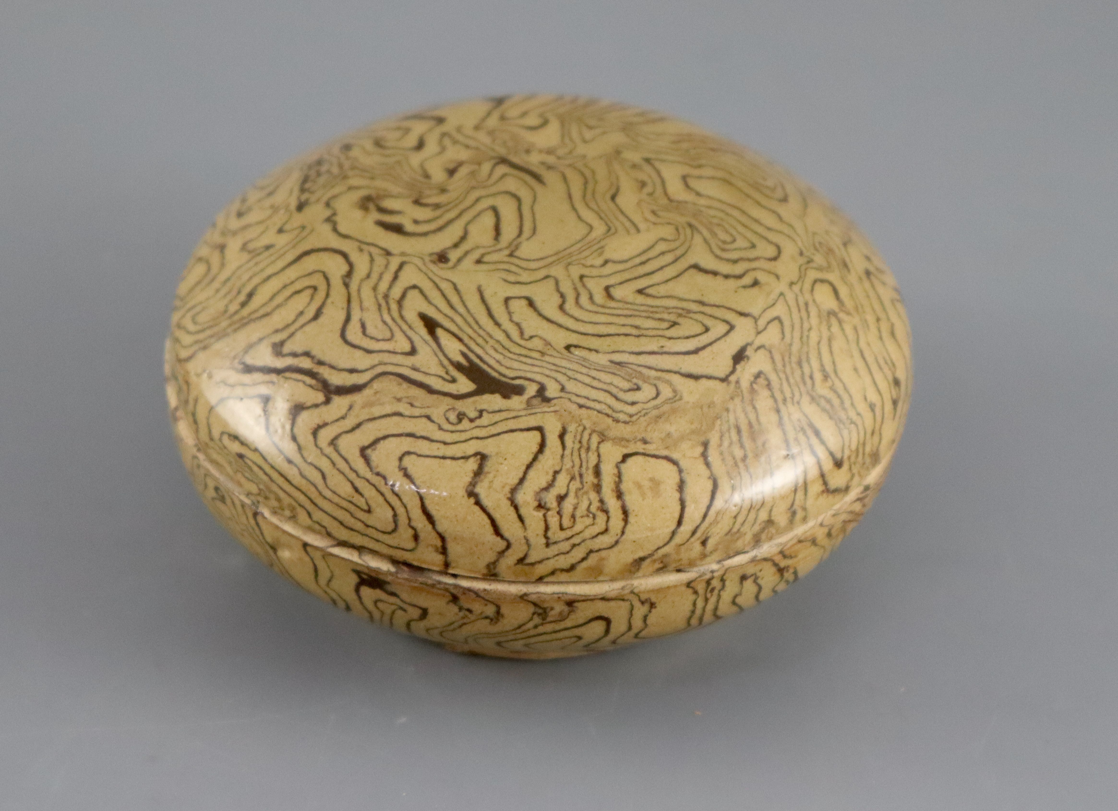 A Chinese marbled straw glazed box and cover, Tang dynasty or later, 11cm diameter